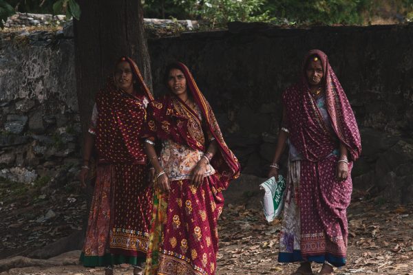 Three rural women walking together down a street in India.