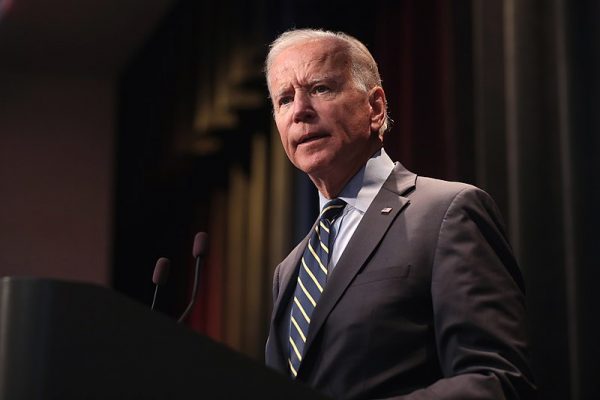 Joe Biden stands in front of a podium.